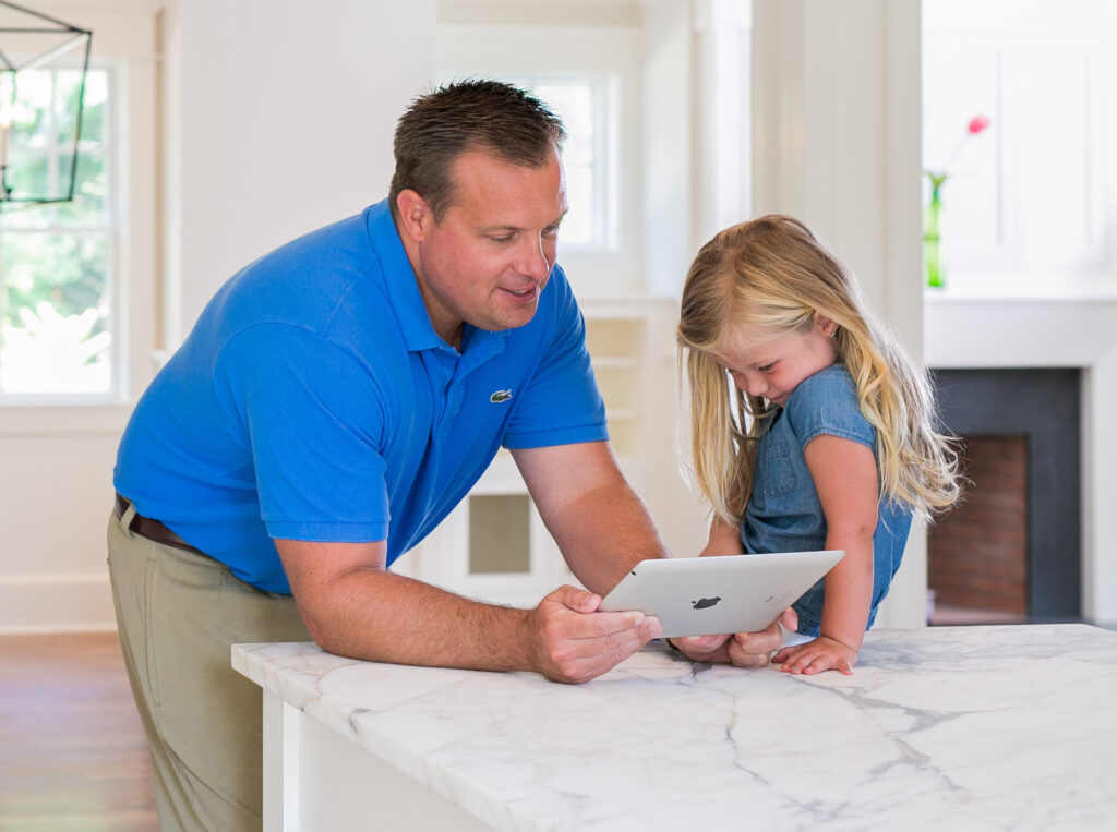 man teaching her daughter on laptop